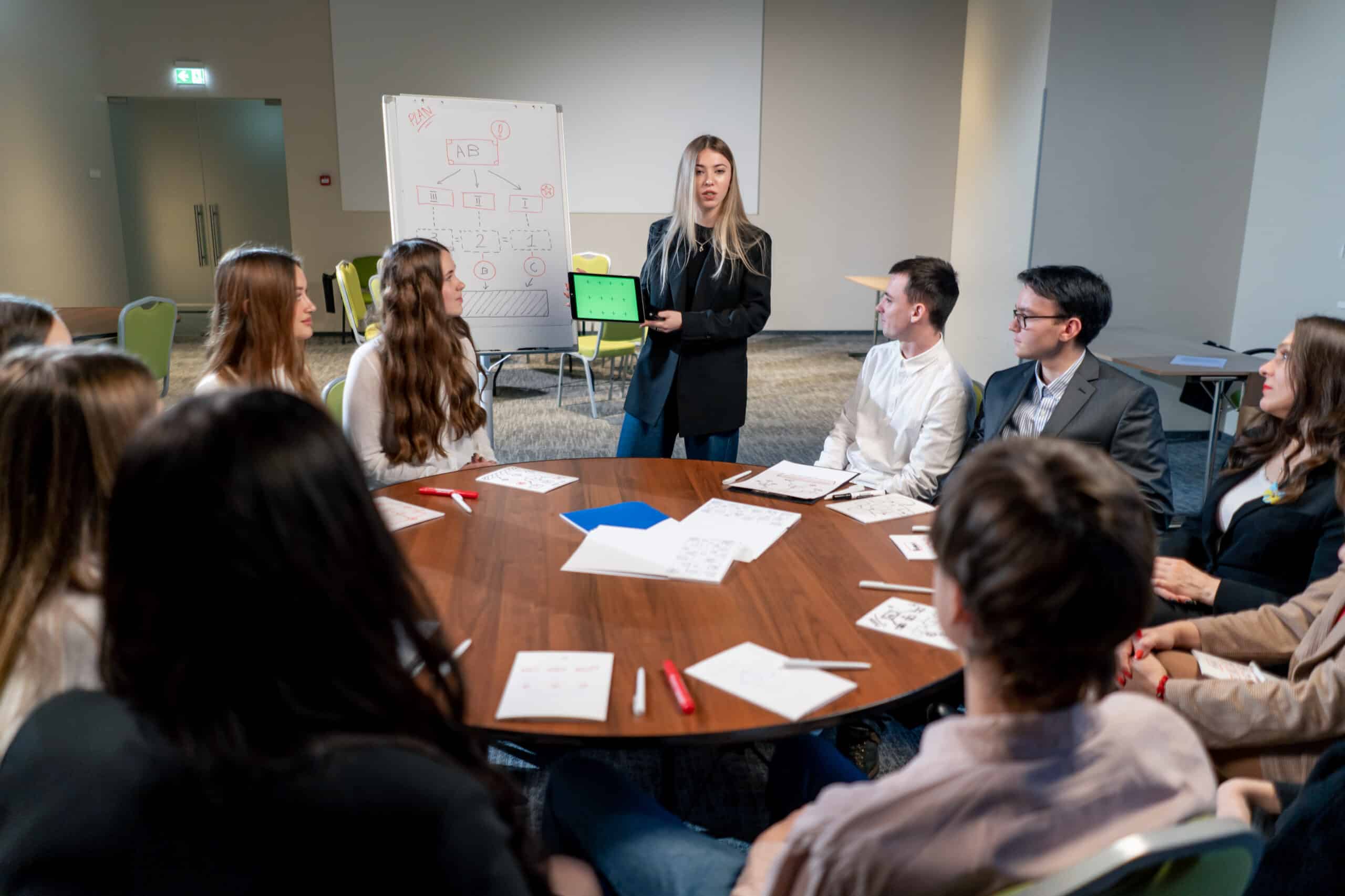 the manager holds a tablet with a green screen in his hands tells his colleagues about the development plan for company
